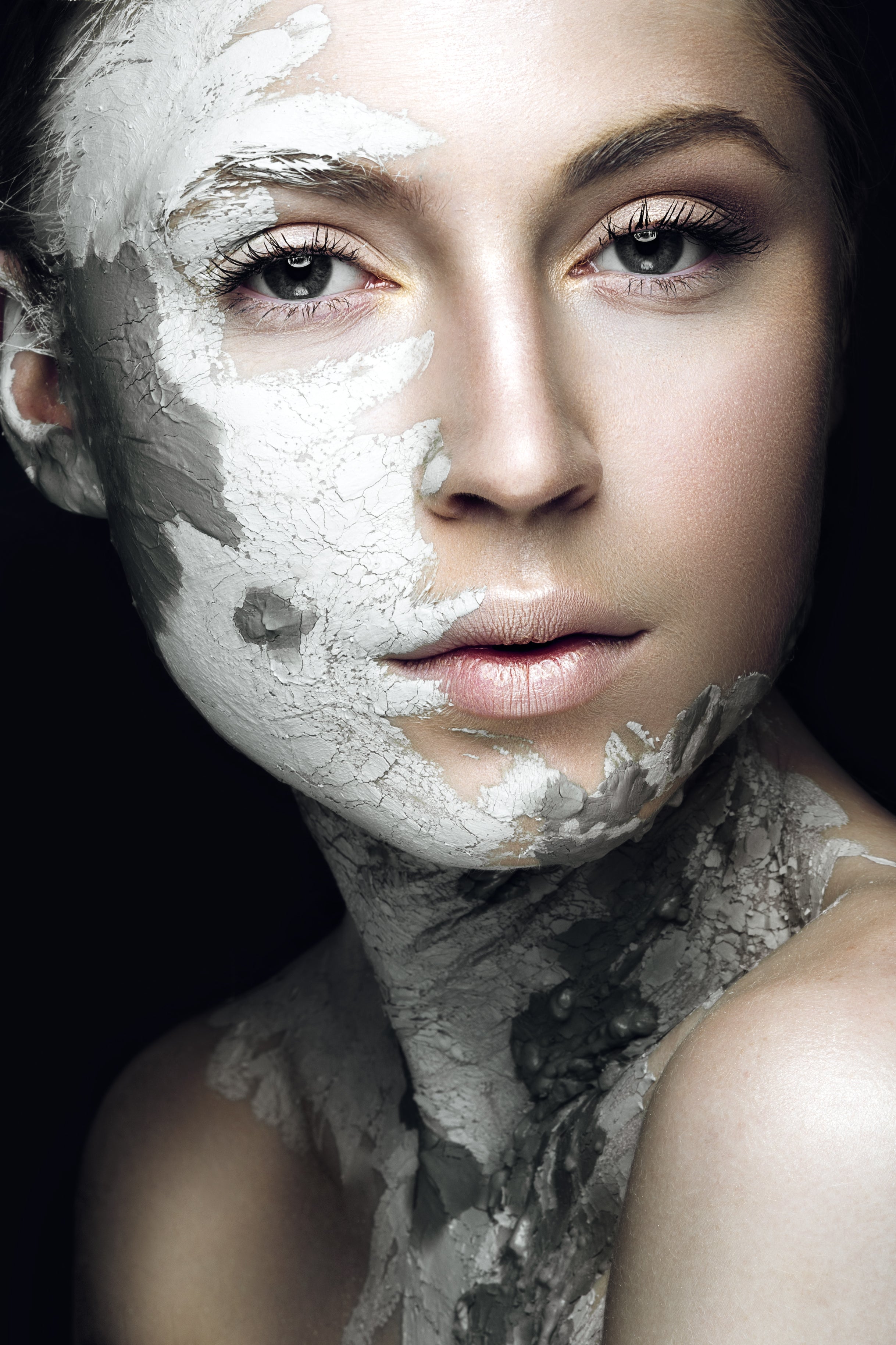 Woman with smooth skin using exfoliating clay mask for sensitive skin